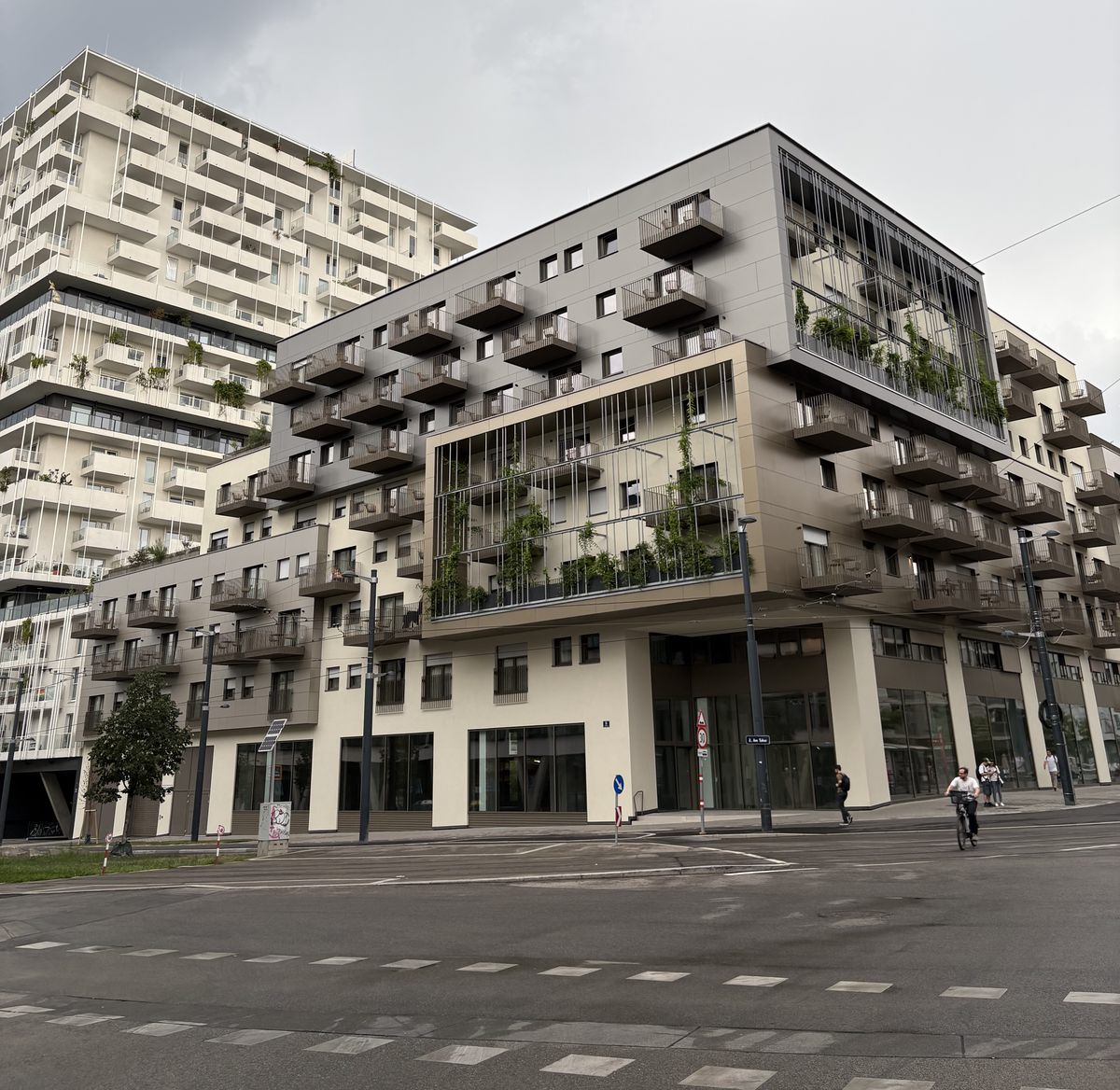 New building with a planted facade and balconies on a street corner in a young Viennese quarter